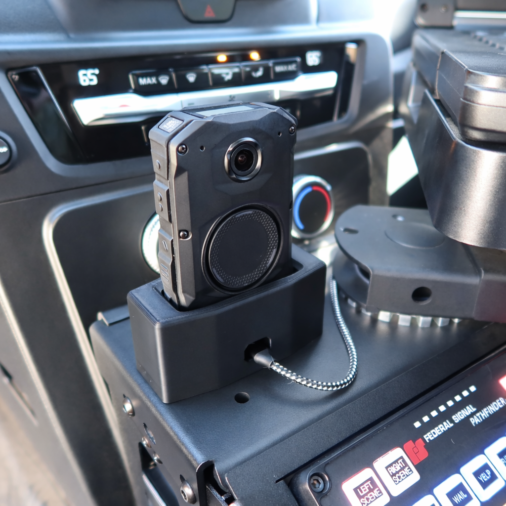 Axon Body 3 or Body 4 camera in magnetic charging dock on patrol vehicle console